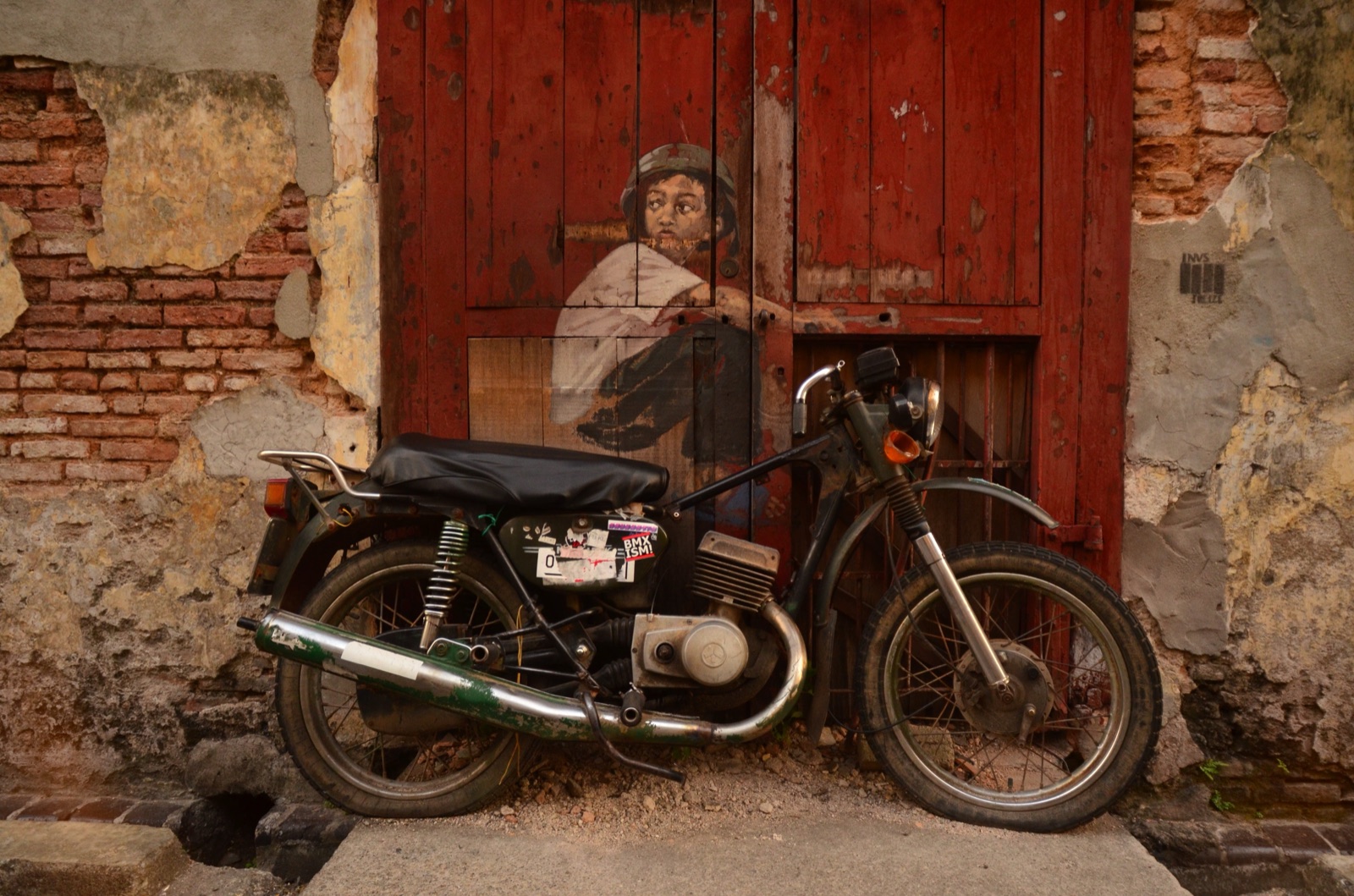 Motocykl zaparkowany przy czerwonej kamienicy w George Town